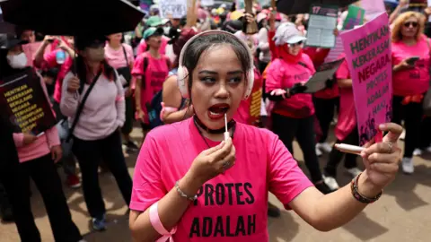 Indonesia: Ratusan perempuan yang membawa sapu ikut serta dalam aksi protes saat Prabowo terbang ke Tiongkok